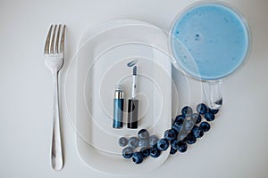 Blue eye makeup on a plate with blueberries