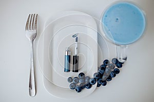 Blue eye makeup on a plate with blueberries