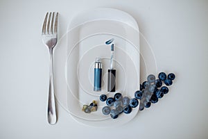 Blue eye makeup on a plate with blueberries