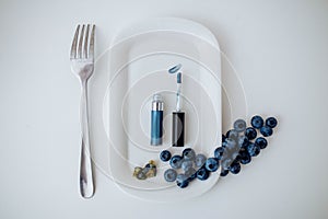 Blue eye makeup on a plate with blueberries