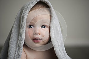 Blue eyed baby boy under grey blanket