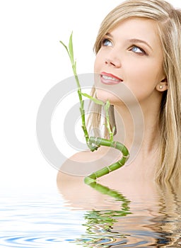 Blue-eyed blonde with bamboo in water