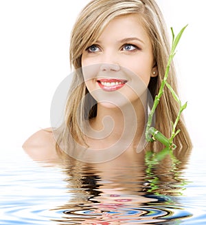 Blue-eyed blonde with bamboo in water