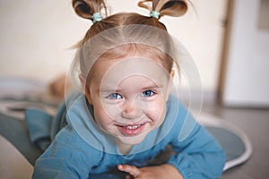 Blue-eyed blonde girl in a vintage blue dress smiling