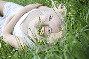 Blue-eyed Blonde Lying on the Grass