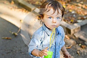 Blue eyed boy in the park with fallen leaves