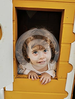 Blue-eyed girl playing in the dollhouse