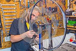 Blue eyed guy repairing bicycle in the workshop