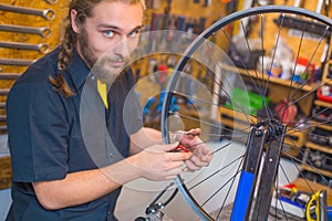 Blue eyed guy repairing bicycle in the workshop
