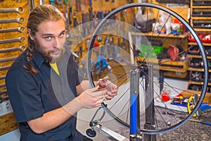 Blue eyed guy repairing bicycle in the workshop