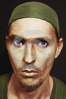 Blue-eyed men with gold makeup in green headscarf