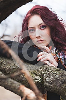 Blue eyes pretty young woman portrait otdoor lean on tree branch winter or autumn cold day photo