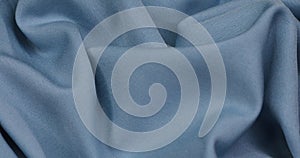 Blue fabric background. Blue cloth waves background texture.