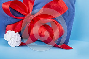 Blue fabric with a red ribbon on a blue background.