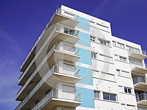 Blue facade white apartment real estate building exterior architecture in blue summer sky