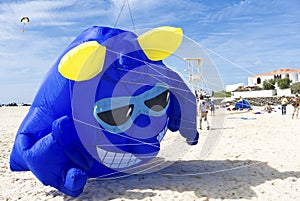 Blue fantasy monster kite taking off for blue skies at the beach