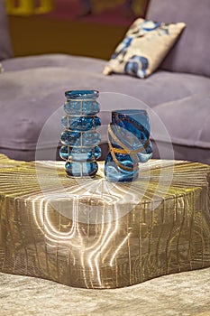 Blue fashionable glass vases on the gold modern table. Stylish interior art deco.