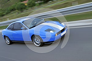 Blue fast racing car on the highway
