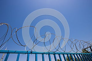 Blue Fence made of wire with spikes on top