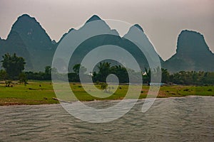 Blue ferry and karst mountains along Li River in Guilin, China