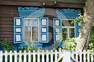 Blue figured wooden frame windows. Window frame of different shapes in the form of vertical strips and lozenges. Belarus
