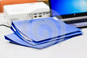 Blue file folder with documents on the white table
