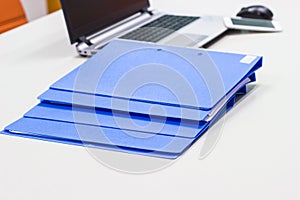 Blue file folder with documents on the white table