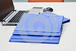 Blue file folder with documents on the white table