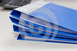 Blue file folder with documents on table in work office