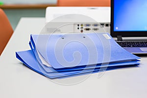 Blue file folder with documents on the white table