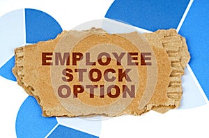 On the blue financial charts is a piece of cardboard that says - Employee Stock Option