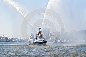 Blue fire boat spraying water in Rotterdam harbor Netherlands