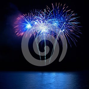 Blue fireworks above water
