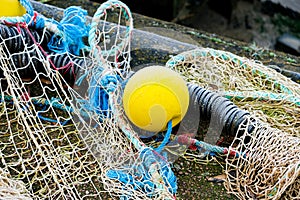 Blue fishing net on a pontoon with its ropes and floats covered with morning frost
