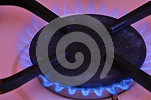 A blue flame from a gas cooktop burner. Stove turbo burner with burning flame closeup