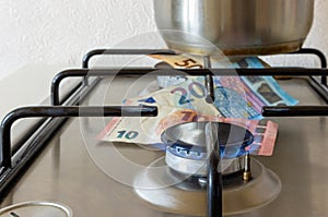 Blue flame of gas stove burner with euro money