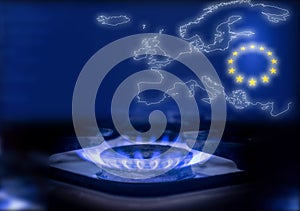 The blue flame of a gas stove in the dark. Gas burner on the background of the map and the flag of the European Union. The concept