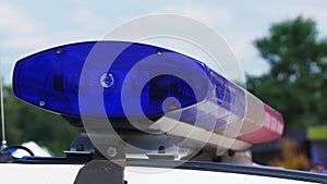 Blue flashing lights on police patrol car at day. Close-up