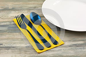 Blue flatware on yellow napkin