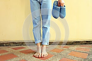 Blue flip flops fashion. Woman wear blue sandals and blue jeans stand on the tile floor background