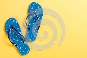 Blue flip flops on yelow Background. Top view with copy space