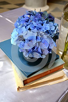 Blue flower decoration placed on an old books on a wedding altar