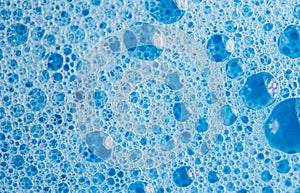 Blue foam. Bable on the water. Dish soap. Background proposal. Photo from above.