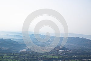 Blue fog covered mountain range in a wide shot from a hill top. Beauty concept