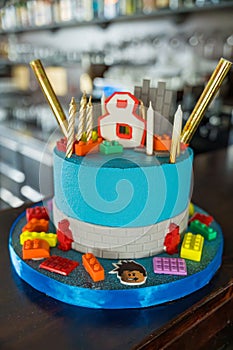 Blue fondant cake with candles and constructor pieces. 8th birthday. Roblox concept. photo