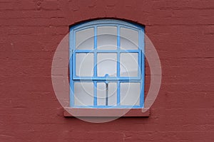 Blue Framed Window with Arch in a Brick Wall