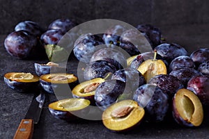 Blue fresh juicy plums on dark table