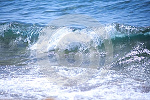 Blue Fresh Water Whitecap Waves Wash Ashore onto a Sandy Beach.
