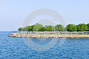 Blue fresh and waving sea water and public park in background