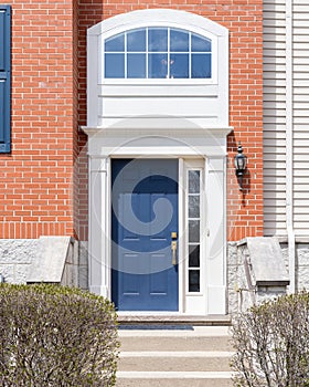 A blue front door on a red brick home.